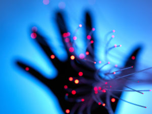 Digital age: artificial intelligence fibre optics carrying data passing through hand Digital age: artificial intelligence fibre optics carrying data passing through hand